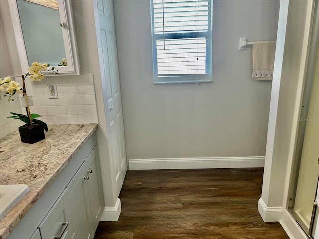 bathroom featuring hardwood / wood-style flooring, vanity, and backsplash