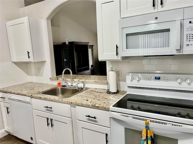 kitchen featuring tasteful backsplash, sink, white cabinets, and white appliances