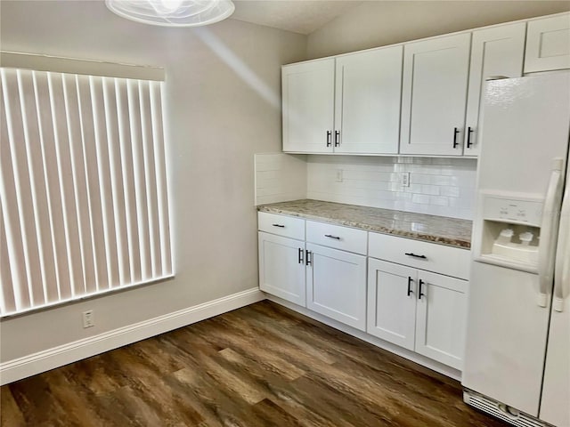 kitchen with dark hardwood / wood-style flooring, white refrigerator with ice dispenser, and white cabinets