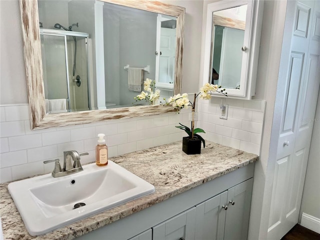 bathroom featuring walk in shower, vanity, and tasteful backsplash