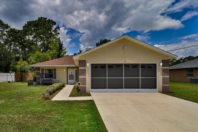 view of front of home featuring cooling unit, a garage, and a front yard