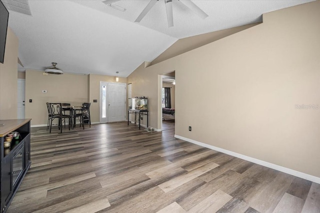 unfurnished living room with vaulted ceiling, ceiling fan, and wood-type flooring