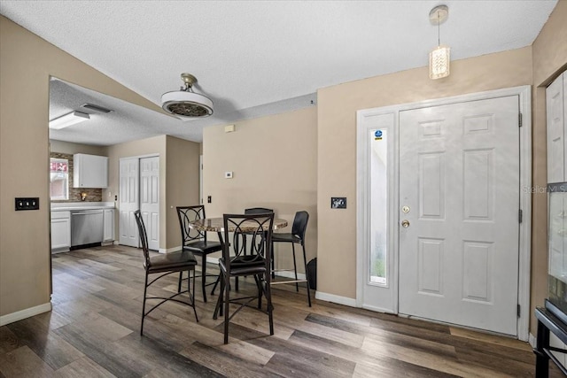 dining space with a textured ceiling and dark hardwood / wood-style floors