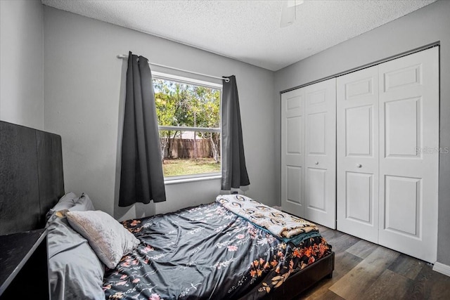 bedroom featuring ceiling fan, dark hardwood / wood-style floors, a textured ceiling, and a closet