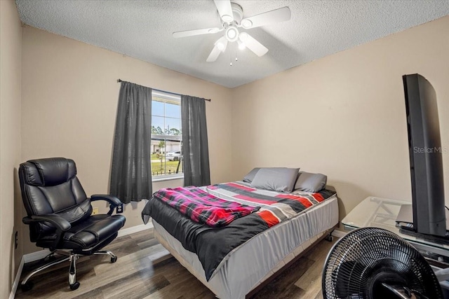 bedroom with hardwood / wood-style flooring, ceiling fan, and a textured ceiling