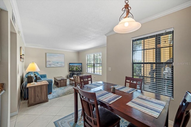 tiled dining room with a textured ceiling and ornamental molding