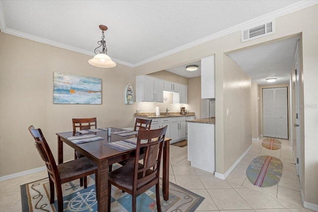 dining area featuring crown molding and light tile patterned flooring