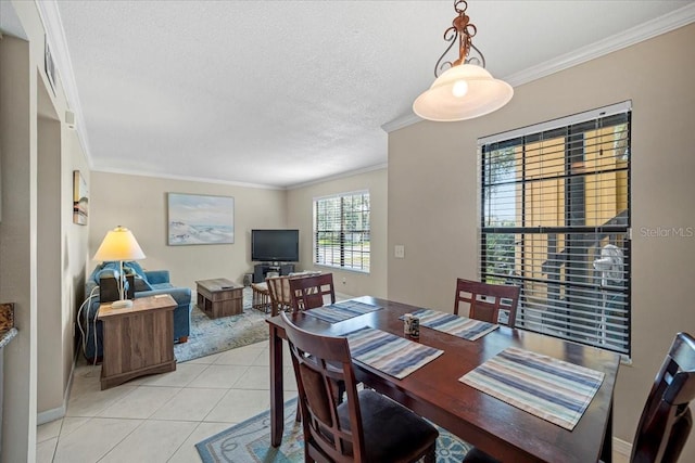 tiled dining area featuring a textured ceiling and crown molding