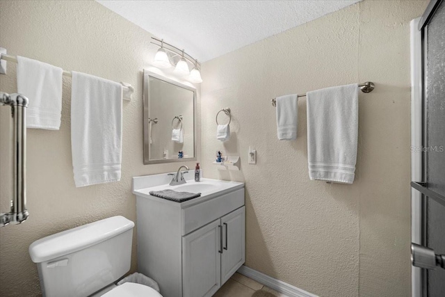 bathroom featuring vanity, tile patterned floors, a textured ceiling, and toilet