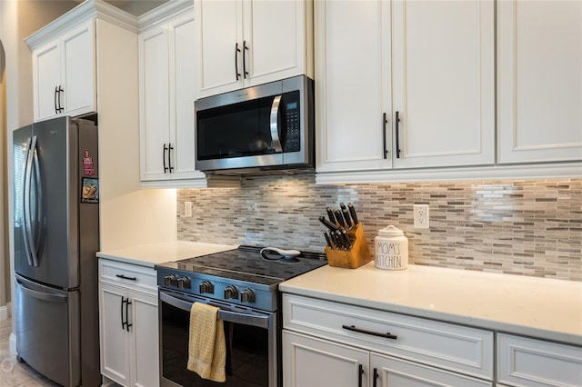 kitchen featuring appliances with stainless steel finishes, tasteful backsplash, white cabinetry, and light stone counters