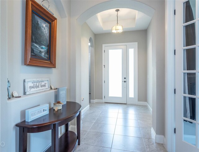 tiled entrance foyer with a raised ceiling