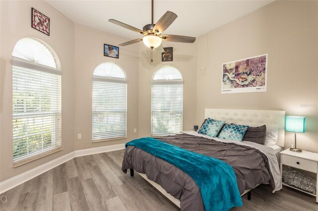 bedroom featuring multiple windows, ceiling fan, and light wood-type flooring