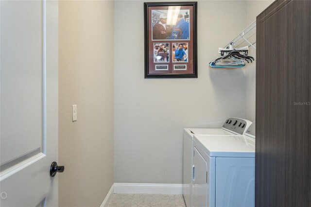 laundry room with light tile patterned floors and washer and clothes dryer