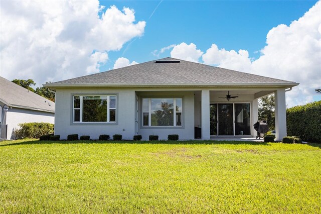 back of property with a lawn, ceiling fan, and a patio