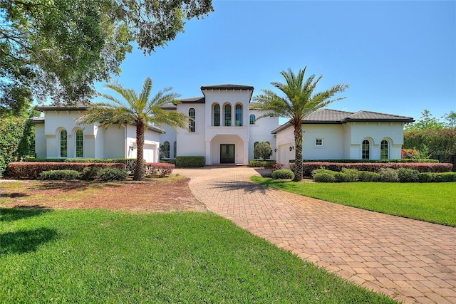 mediterranean / spanish-style house with a front lawn and a garage