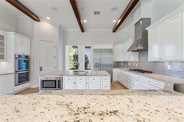 12245 Park Ave, Windermere, FL 34786 - kitchen with built in appliances, wall chimney range hood, light wood-type flooring, tasteful backsplash, and beamed ceiling