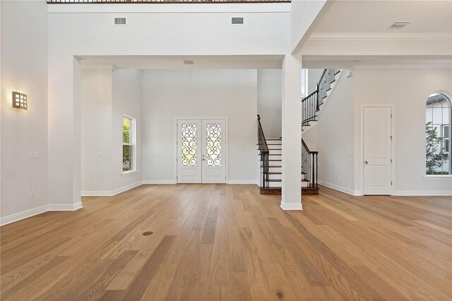 12245 Park Ave, Windermere, FL 34786 - foyer entrance with french doors, stairs, healthy amount of natural light, ornamental molding, and wood finished floors