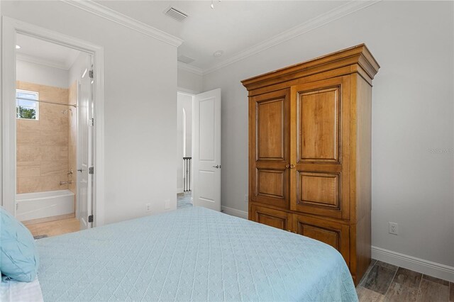 12245 Park Ave, Windermere, FL 34786 - bedroom featuring baseboards, ornamental molding, wood finished floors, and ensuite bathroom
