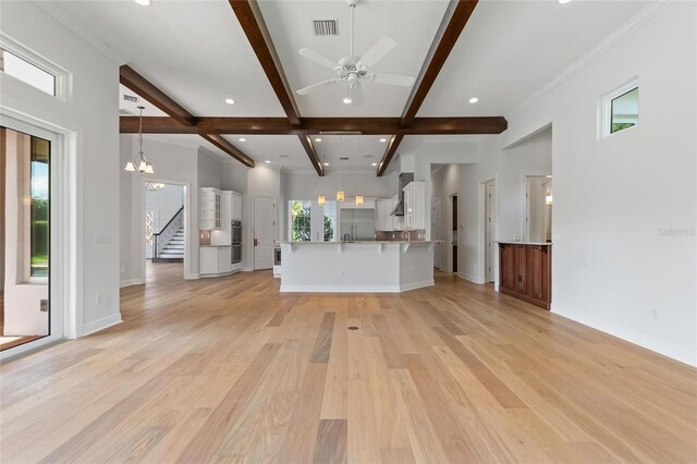 12245 Park Ave, Windermere, FL 34786 - unfurnished living room with beam ceiling, stairway, healthy amount of natural light, light wood-style floors, and recessed lighting