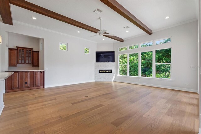 12245 Park Ave, Windermere, FL 34786 - unfurnished living room with light wood-type flooring, ceiling fan, plenty of natural light, a stone fireplace, and beamed ceiling