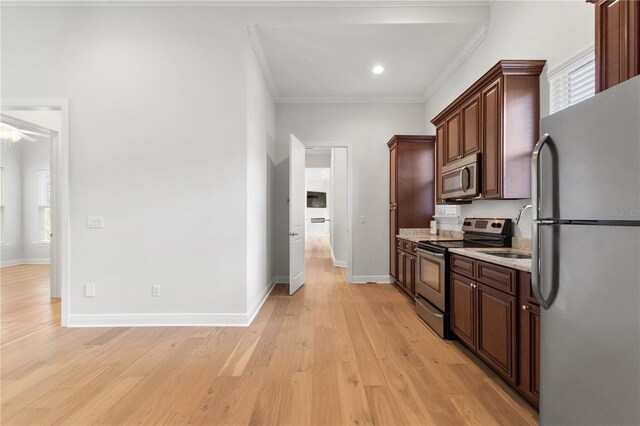 12245 Park Ave, Windermere, FL 34786 - kitchen with stainless steel appliances, light wood finished floors, ornamental molding, a sink, and baseboards