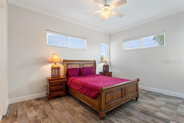 12245 Park Ave, Windermere, FL 34786 - bedroom with crown molding, wood finished floors, baseboards, and a ceiling fan