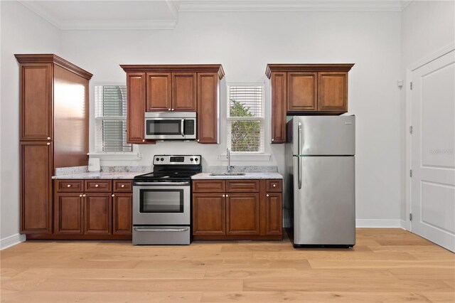 12245 Park Ave, Windermere, FL 34786 - kitchen featuring appliances with stainless steel finishes, a sink, light wood finished floors, baseboards, and ornamental molding