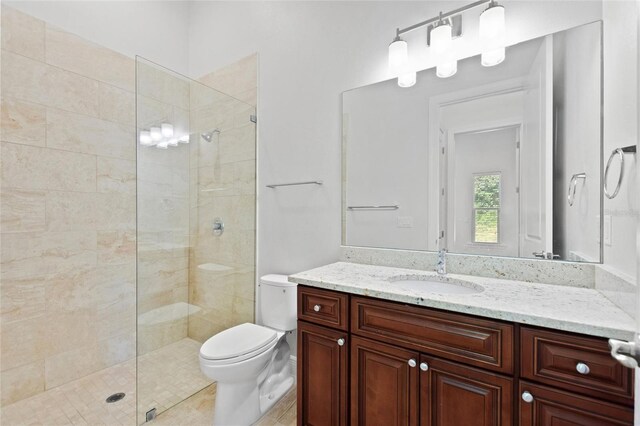 12245 Park Ave, Windermere, FL 34786 - full bathroom featuring a tile shower, toilet, vanity, and tile patterned flooring