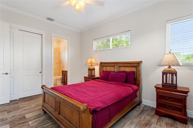 12245 Park Ave, Windermere, FL 34786 - bedroom with multiple windows, wood finished floors, ornamental molding, ensuite bath, and a closet
