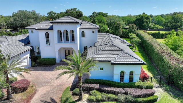 12245 Park Ave, Windermere, FL 34786 - view of front of property with fence, stucco siding, decorative driveway, an attached garage, and a gate