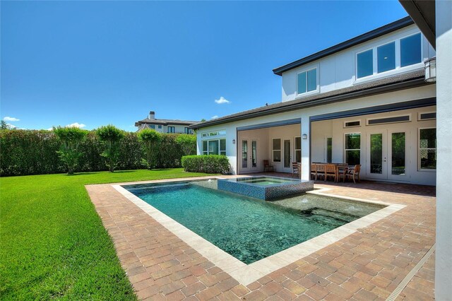 12245 Park Ave, Windermere, FL 34786 - back of property with french doors, a lawn, a patio, stucco siding, and a pool with connected hot tub