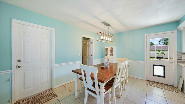 dining space featuring light tile patterned flooring and a notable chandelier