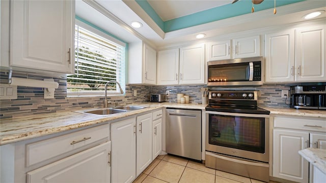 kitchen featuring sink, appliances with stainless steel finishes, white cabinets, and backsplash