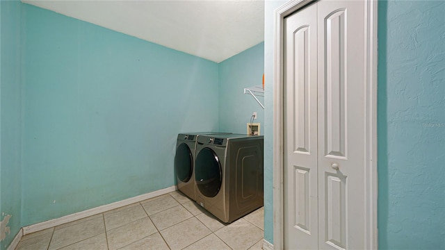 laundry area featuring washing machine and dryer and light tile patterned floors