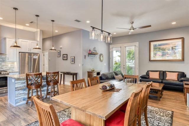 dining space featuring french doors, light hardwood / wood-style flooring, and ceiling fan