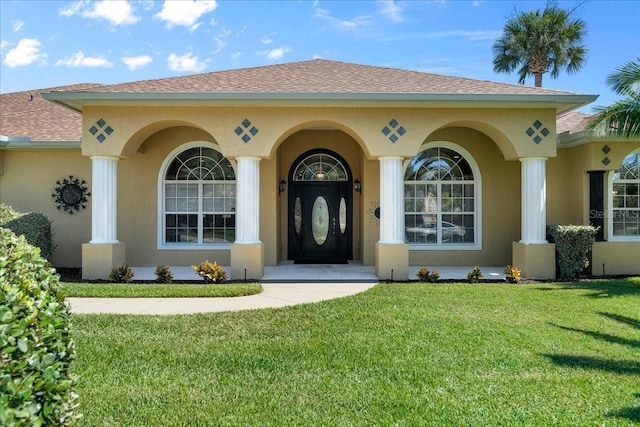 entrance to property featuring a lawn