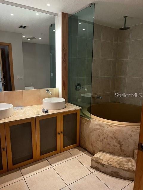 bathroom featuring tiled shower / bath, tile patterned floors, and vanity