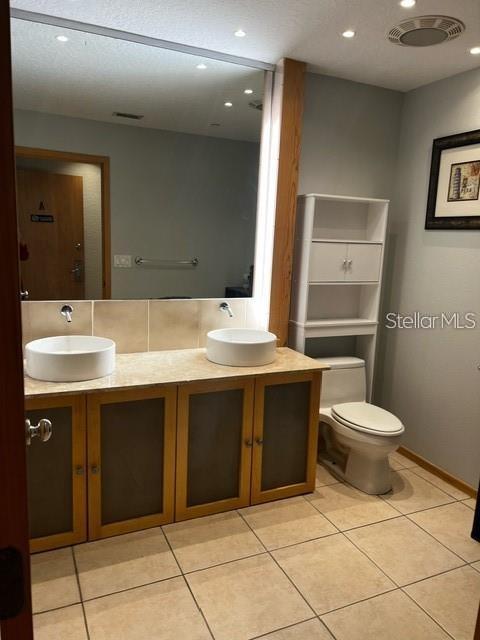 bathroom with tile patterned floors, vanity, and toilet