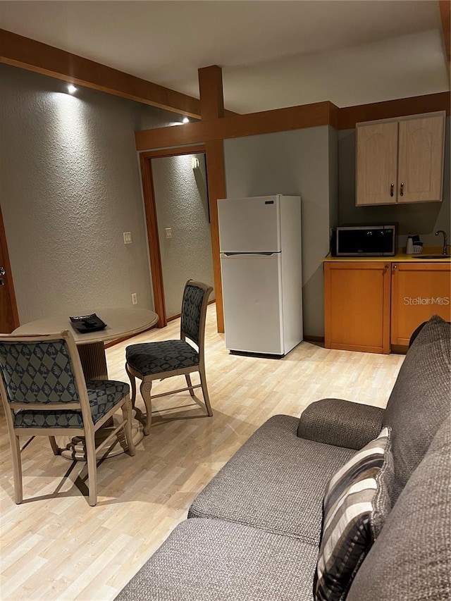 kitchen featuring sink, white refrigerator, and light wood-type flooring