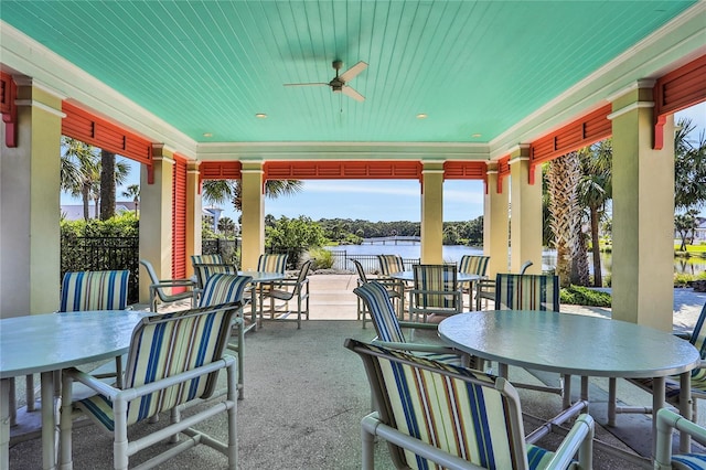 view of patio featuring a water view, outdoor dining area, and a ceiling fan