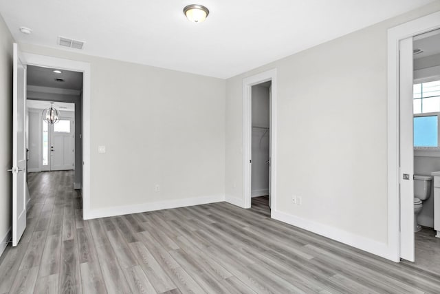 unfurnished bedroom with light wood-style floors, visible vents, and baseboards