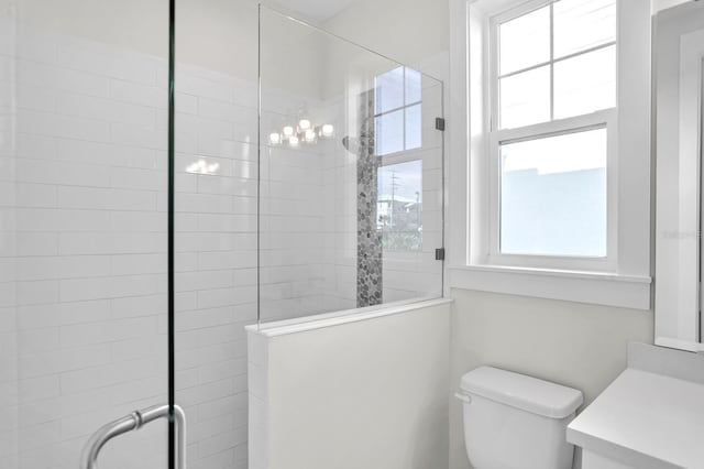 bathroom featuring a tile shower, vanity, and toilet