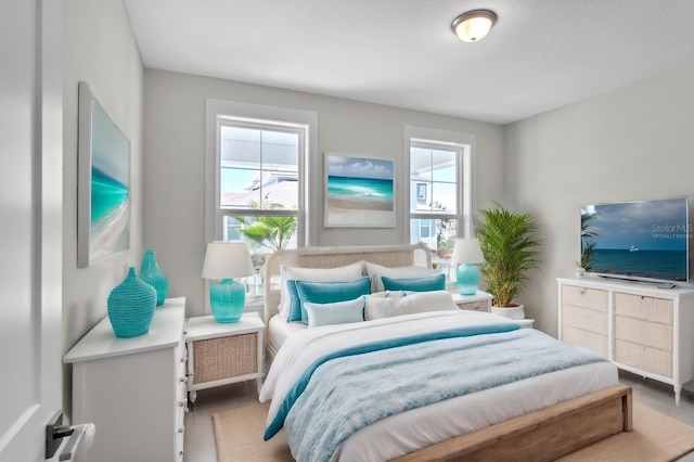 bedroom with multiple windows and wood finished floors