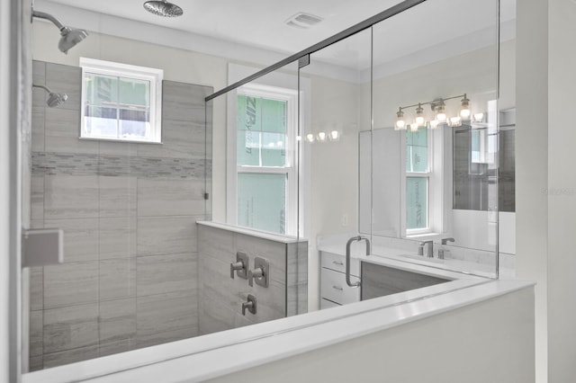 bathroom featuring tiled shower and vanity