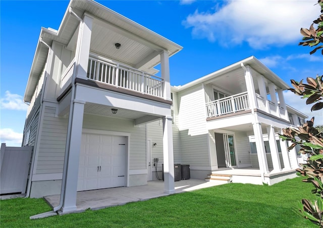 back of property with a garage, a yard, and a balcony