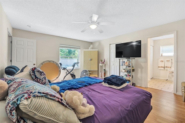 tiled bedroom with a textured ceiling, ensuite bathroom, and ceiling fan