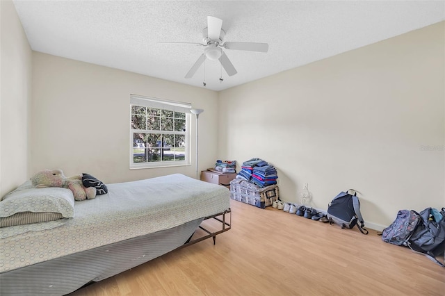 bedroom featuring ceiling fan, a textured ceiling, and light hardwood / wood-style flooring