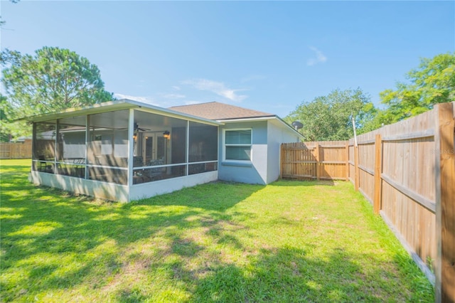 rear view of property with a sunroom and a lawn