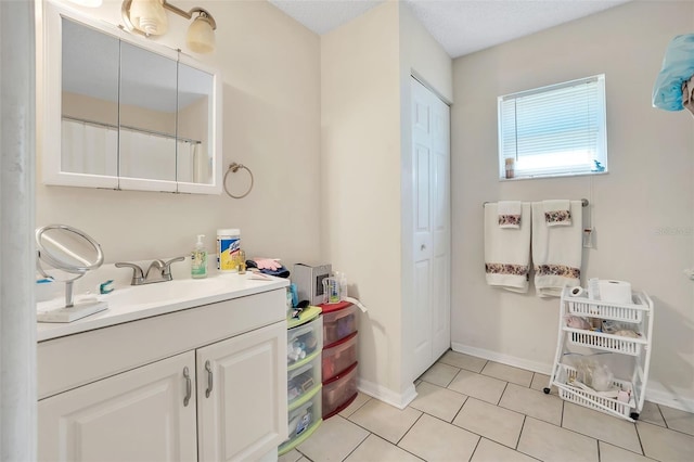 bathroom featuring tile patterned floors, vanity, and a textured ceiling