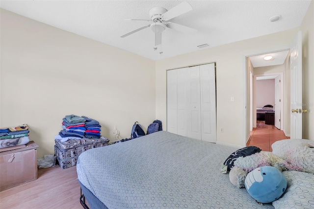 bedroom with a closet, wood-type flooring, and ceiling fan